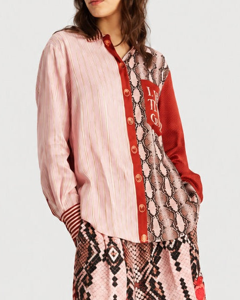 The ME369 Isabel Shirt Red Aura is a color-blocked button-down featuring pink vertical stripes, a red side panel, and a snake-patterned section with text on the pocket.