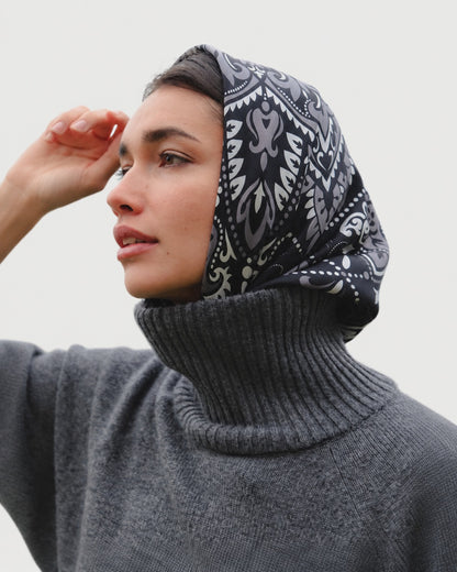 Maison Lecomte Flament Black bandana scarf worn as a headscarf with a dark sweater.