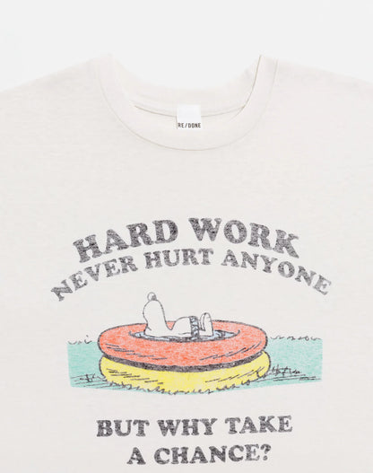The RE/DONE Hard Work Snoopy Tee is a white recycled cotton t-shirt with Snoopy on a pool float. "HARD WORK NEVER HURT ANYONE" appears above, and "BUT WHY TAKE A CHANCE?" below. Perfect for vintage Peanuts fans.