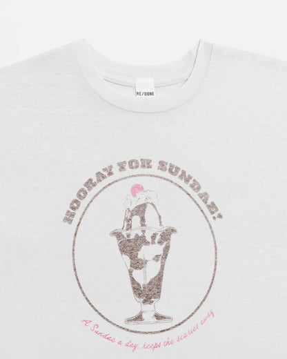 The Sundae Tee by RE/DONE is a white vintage-style t-shirt featuring an ice cream sundae with "HOORAY FOR SUNDAY!" above and "A Sundae a day keeps the scaries away." below, made from soft recycled cotton.