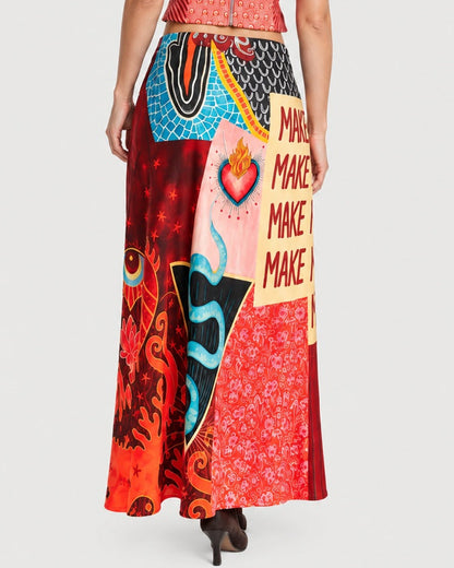 The ME369 Blakely Slip Skirt Red Aura is a long, graphic slip skirt featuring a colorful collage of patterns including hearts, flames, stars, and the repeated word “MAKE.”