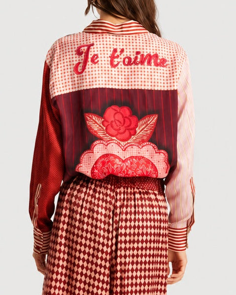 Back view of the ME369 Isabel Shirt Red Aura, featuring a mix of red and white patterns, an embroidered “Je t’aime” across the shoulders, and a large rose graphic on the back.