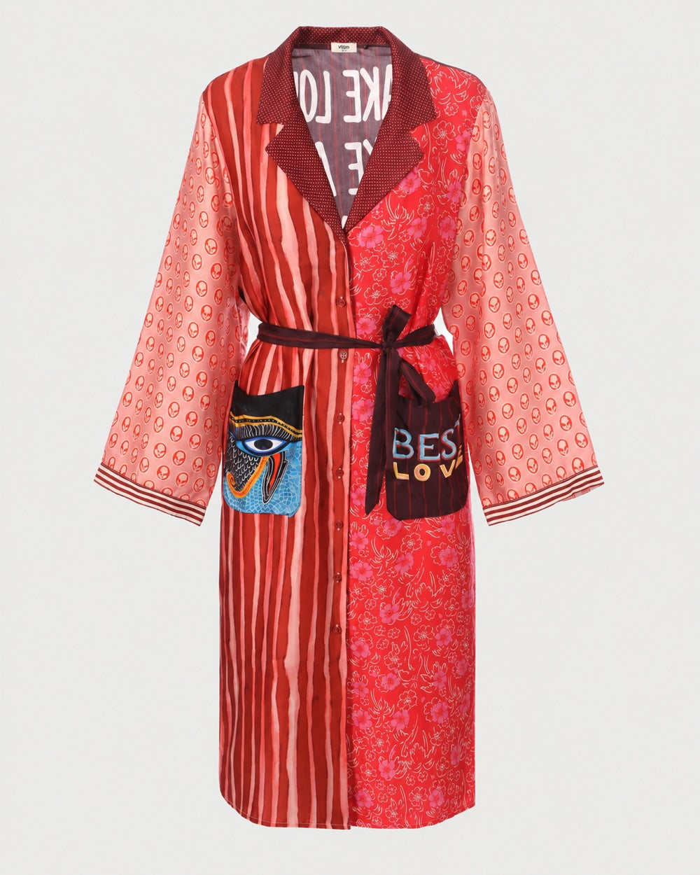 ME369 Nova Kimono Dress Red Aura with long sleeves in mismatched red patterns, featuring a waist tie, an eye graphic on one pocket, and the word “LOVE” on the other.