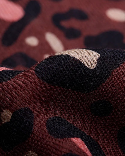 Close-up of the Maison Lecomte Flament Leo Chocolate Rosy scarf’s pink and brown leopard print.