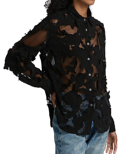 A person wears the R13 Slim Abstract Print Shirt—a black sheer long-sleeve with frayed patches, collar, and distressed details that reveal skin—paired with blue jeans.