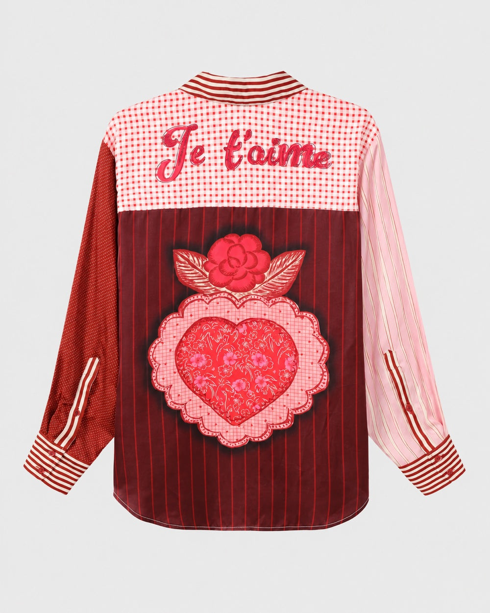 The ME369 Isabel Shirt Red Aura features a mix of red and pink patterns, a “Je t’aime” script across the back yoke, and a large heart and rose patch on the back.