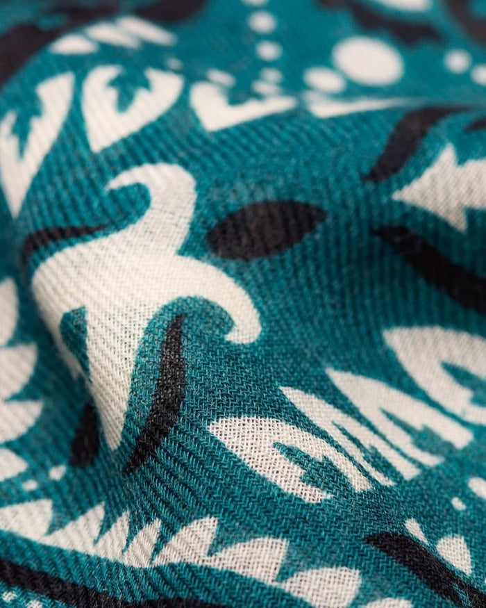 Close-up of the Maison Lecomte Flament Petrol scarf’s teal and ivory bandana print.