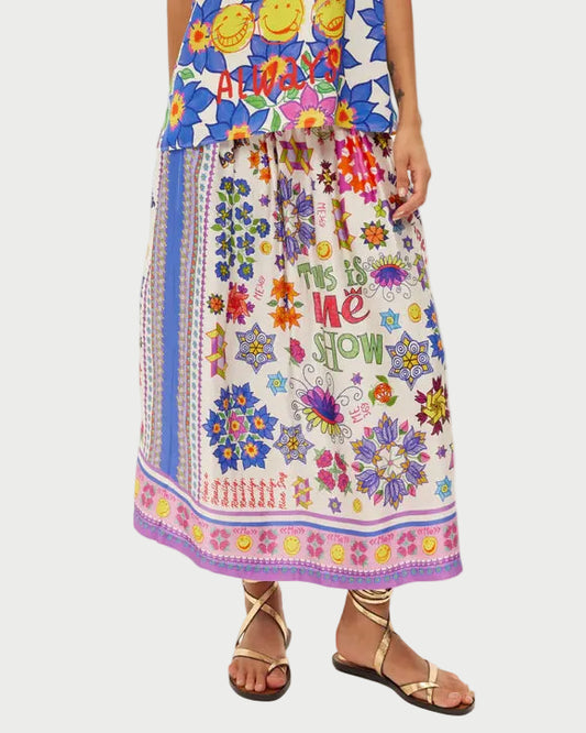 Woman wearing a colorful dress with floral and abstract patterns on a white background