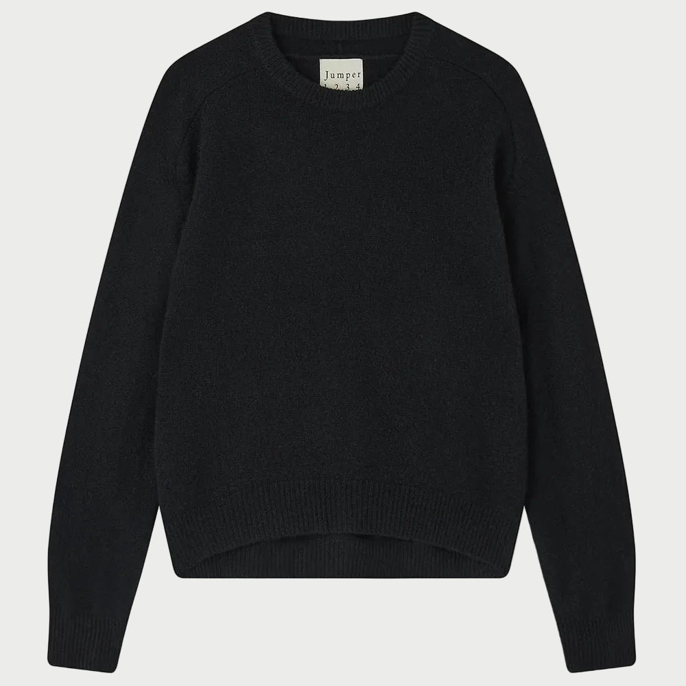 An oversized black cashmere crew neck sweater from JUMPER1234, the Jumper 1234 Oversize Cashmere Crew, is laid flat on a white background with a small cloth label visible inside the collar.