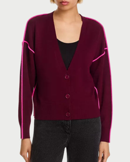 Burgundy cardigan with pink trim worn by a person on a white background