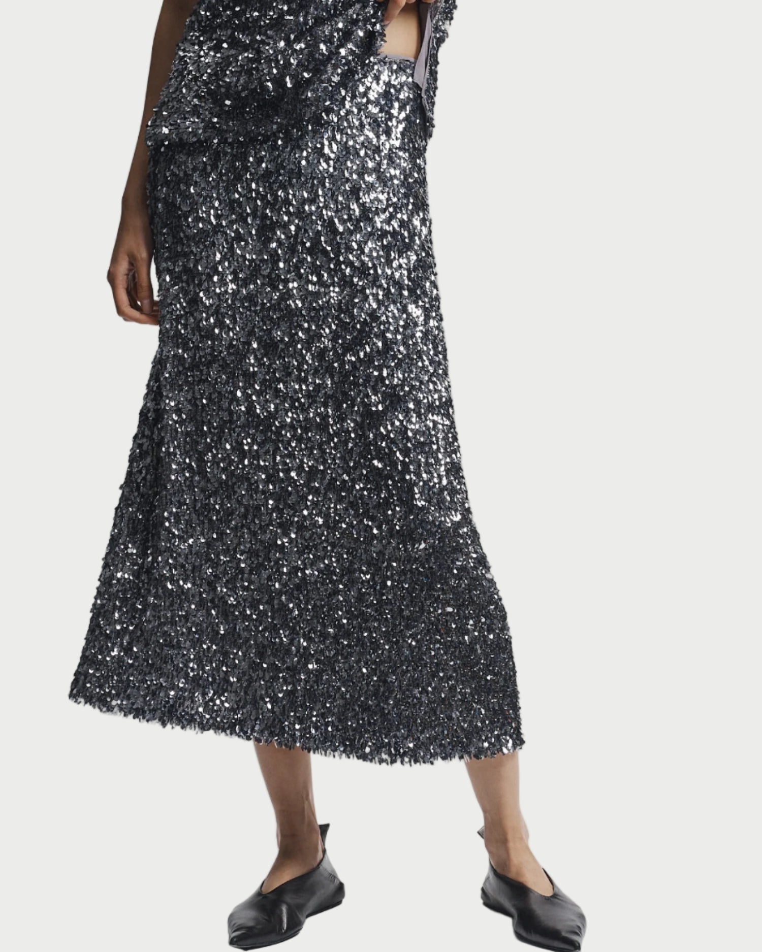 Person wearing a black sequin dress on a white background