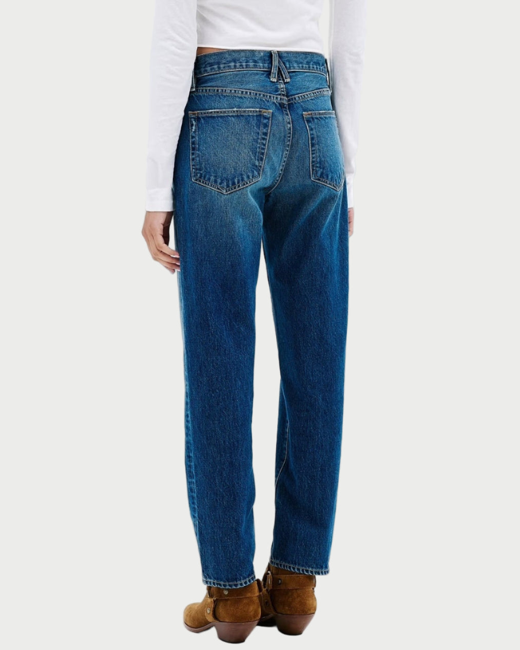 Person wearing blue jeans and a white shirt on a white background