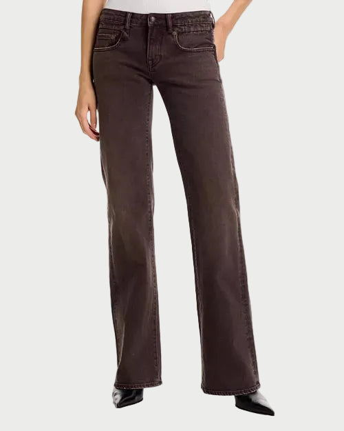 A person wearing dark brown wide-leg jeans with a faded wash, paired with black pointed-toe heels, shown against a plain white studio background.