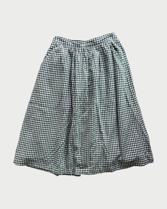 The 172 Check Skirt by A Friend Made is a pre-loved black and white gingham midi with a gathered waistband and loose, flowy silhouette, shown laid flat on a white background.