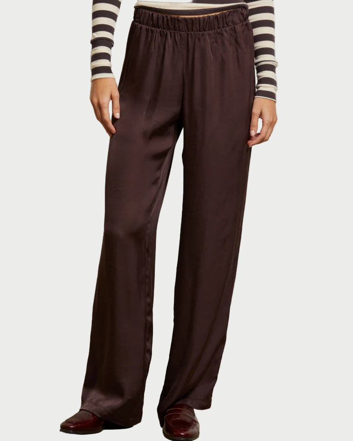 Person wearing brown wide-leg pants and a striped shirt against a plain background