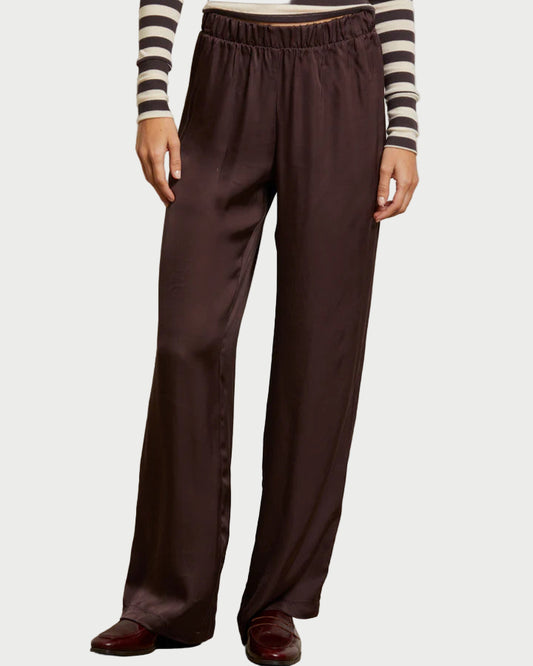Person wearing brown wide-leg pants and a striped shirt against a plain background