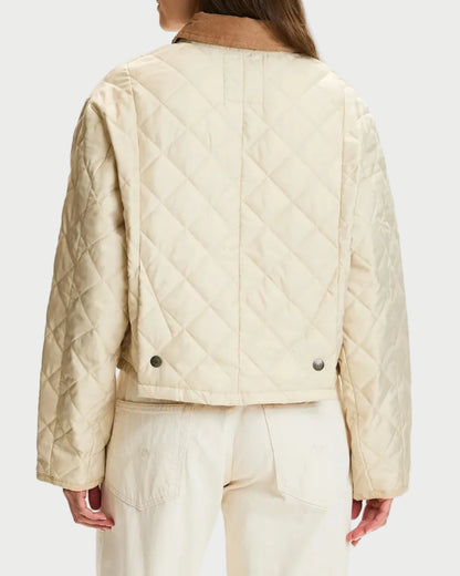A model shown from the back wearing a quilted cream jacket and matching wide-leg trousers against a plain white studio background.
