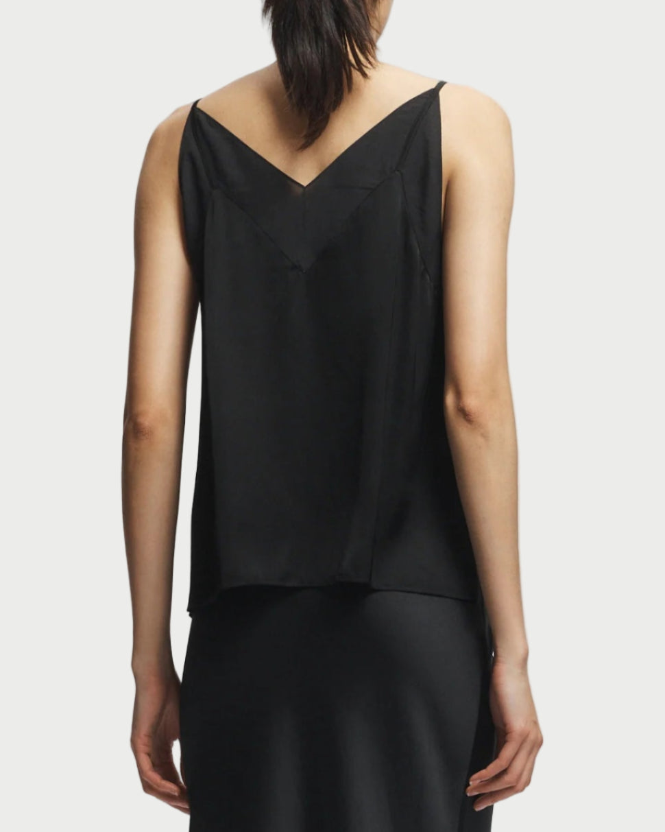 Person wearing a black sleeveless top and skirt set on a white background