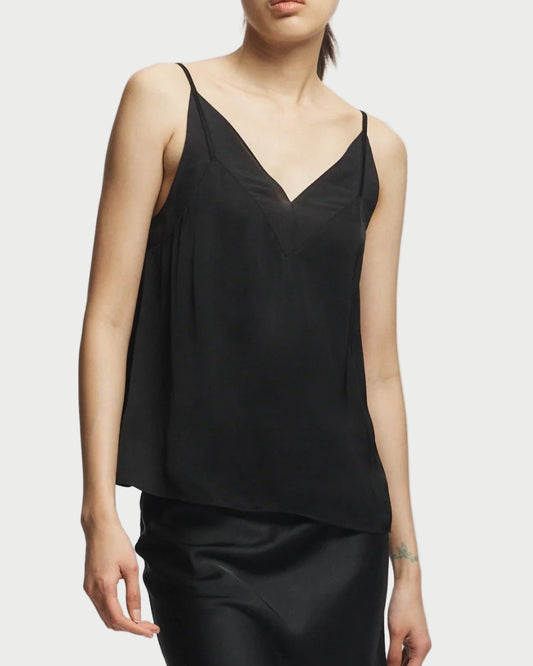 Person wearing a black sleeveless top and skirt set on a white background
