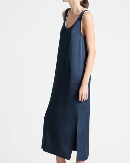 Woman wearing a navy sleeveless dress on a white background