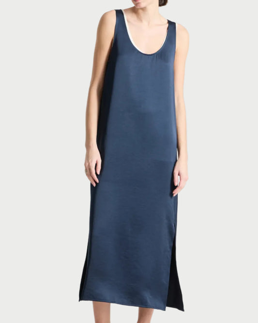 Woman wearing a sleeveless navy dress on a white background