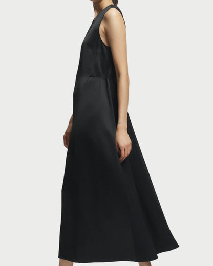 Black sleeveless dress worn by a person on a white background