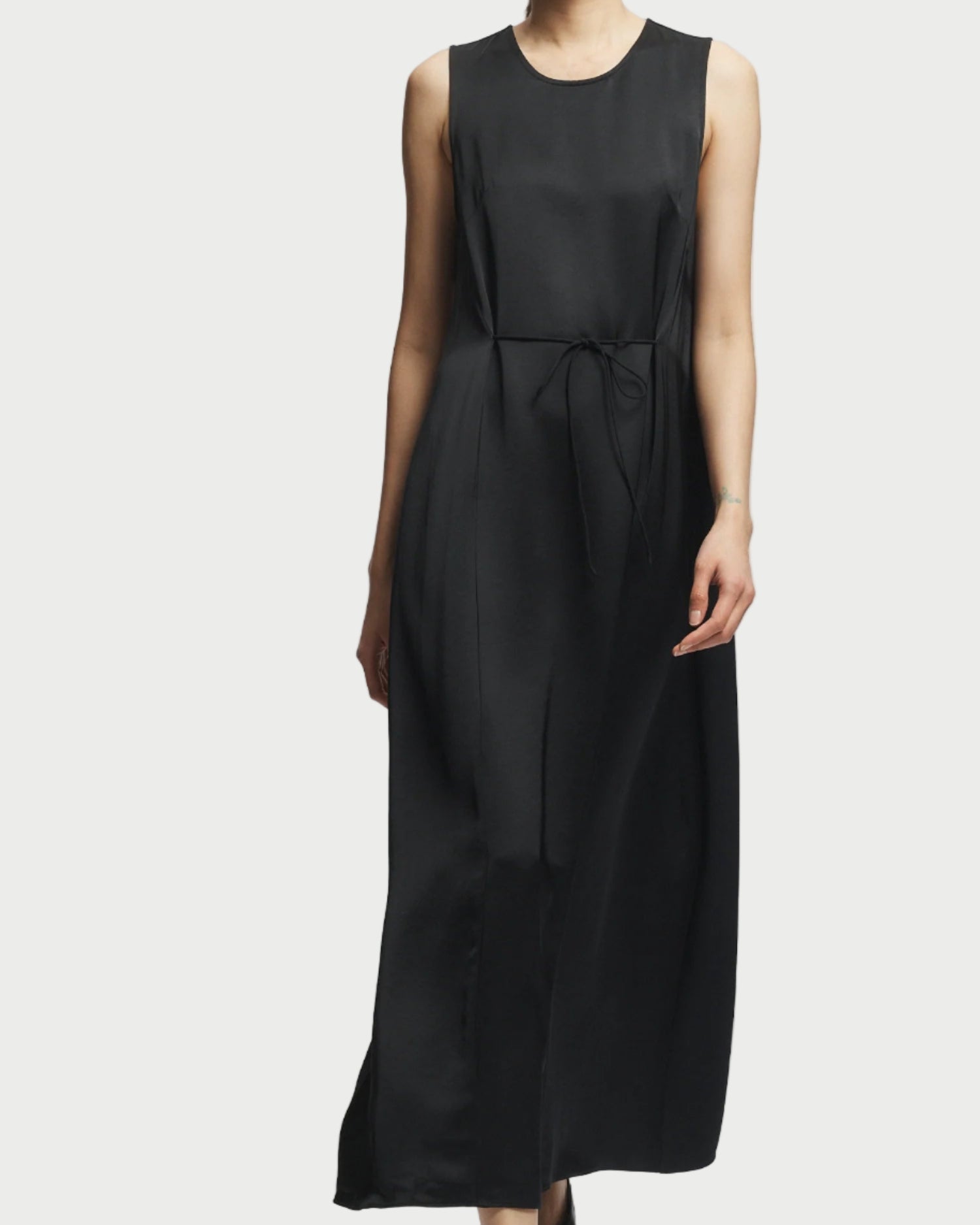 Black sleeveless dress worn by a model on a white background