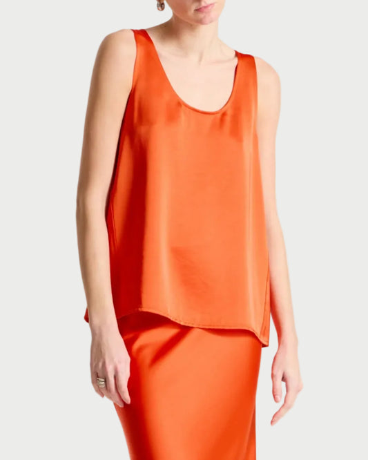 Person wearing an orange sleeveless top and skirt set on a white background