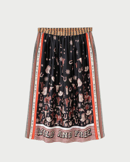 The ME369 Vanessa Skirt Rodeo is a black pleated midi skirt with a vibrant Western rodeo print—cowboy hats, boots, cacti, and horses. “WILD AND FREE” accents the hem, and the elastic waistband features a woven design.