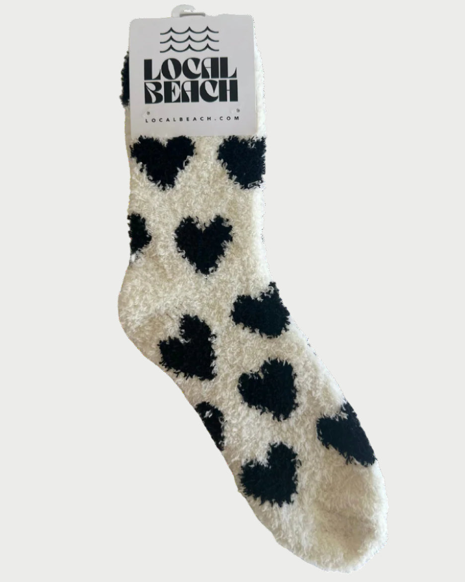 Beige sock with black heart patterns on a white background, featuring 'Local Beach' branding.