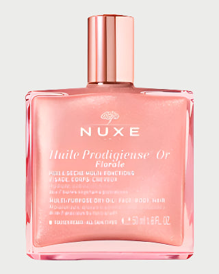A luxurious dry oil for face, body, and hair, NUXE's Florale Dry Body Oil comes in a square rose gold bottle with French text on the label and is elegantly topped with a metallic pink cap.