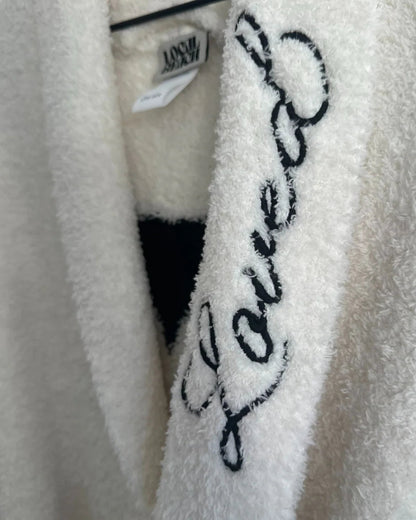White fluffy robe with 'Love' embroidery on a hanger
