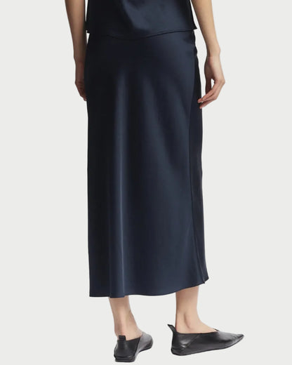 Person wearing a black slip dress on a white background