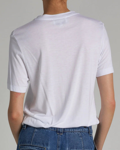 Person wearing a plain white t-shirt and blue jeans against a neutral background