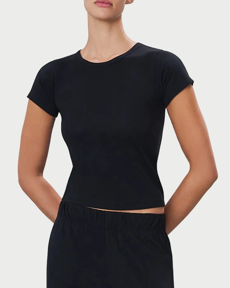 Woman wearing a black tee against a light gray background