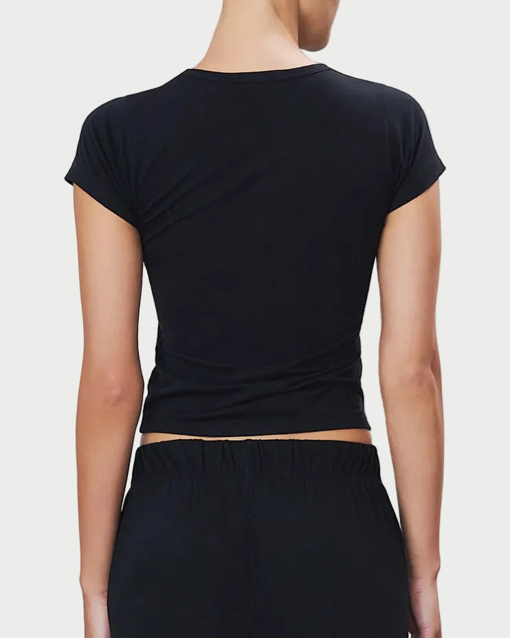 Person wearing a black cap-sleeve top and black pants on a light gray background