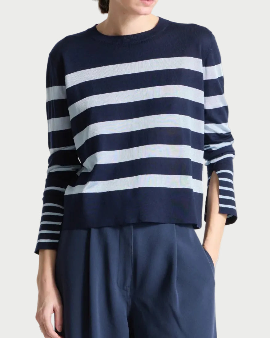 Person wearing a navy and sky striped sweater with wide-leg navy pants on a white background