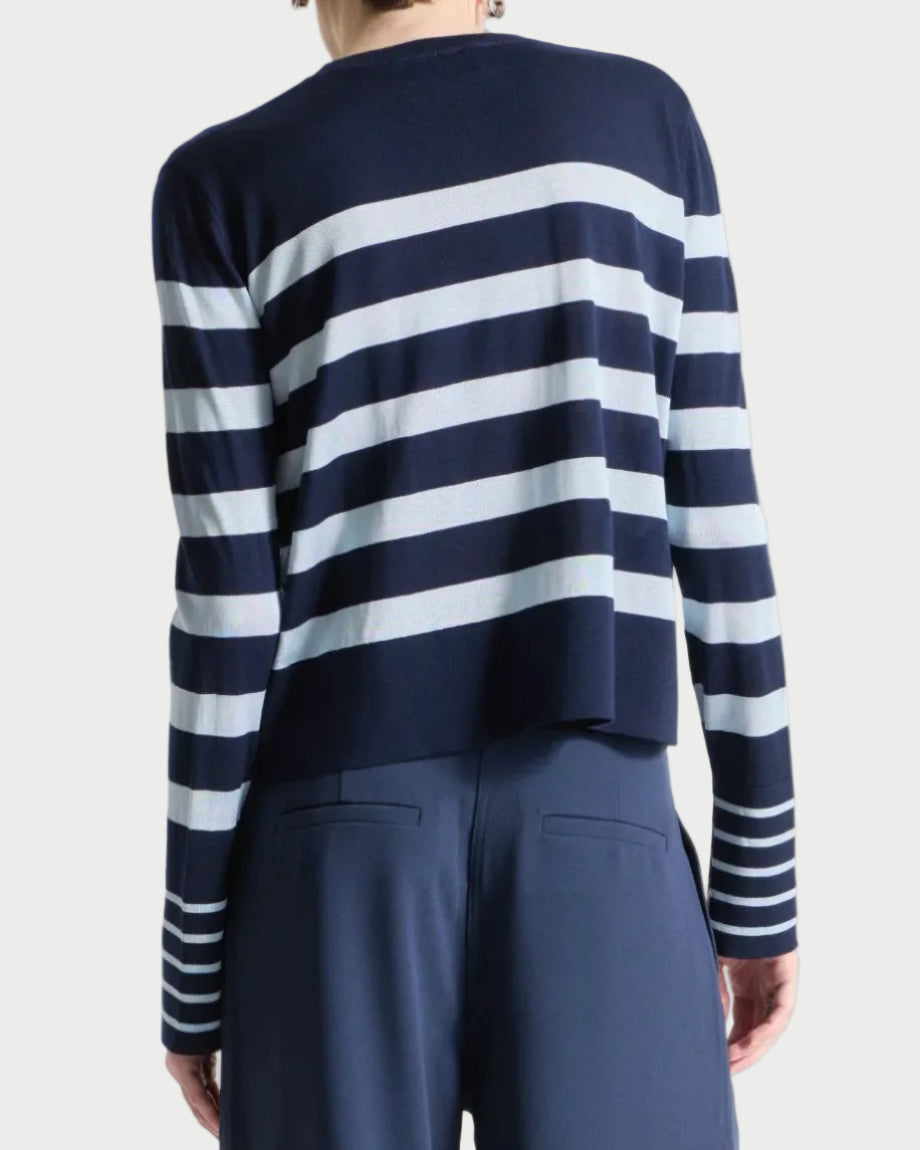 Person wearing a navy and sky striped sweater with wide-leg navy pants on a white background