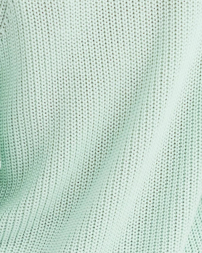 Close-up of a textured light green fabric surface