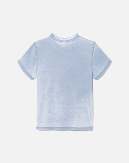 The Montauk Tee by RE/DONE, a light blue short-sleeve vintage shirt with soft, velvety fabric and a subtle burnout finish, is shown laid flat on a plain white background with the back facing up.