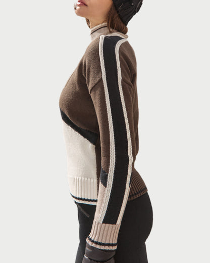 Person wearing a stylish sweater with a mountainous landscape in the background
