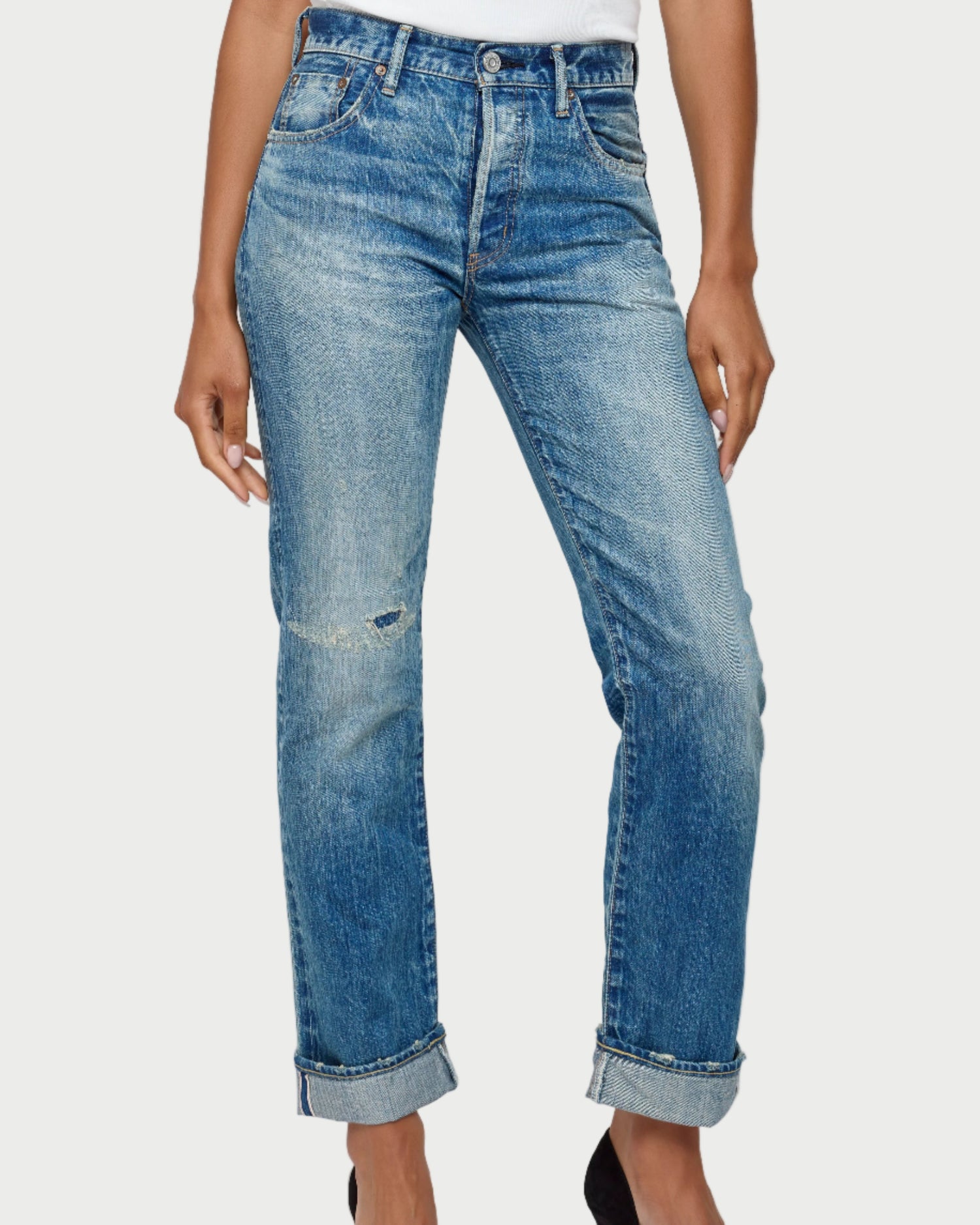Blue jeans worn by a person on a white background