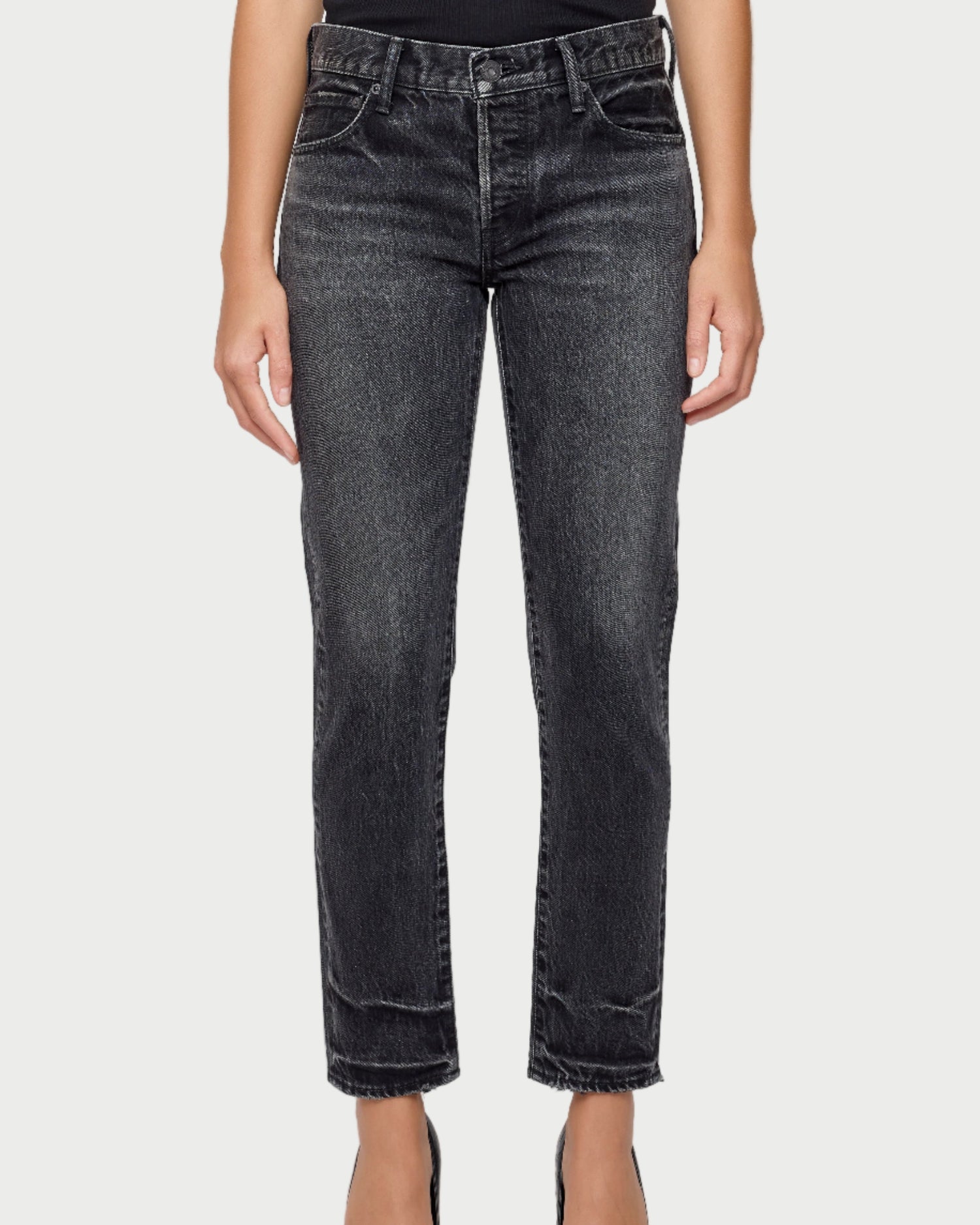 Person wearing black jeans on a white background