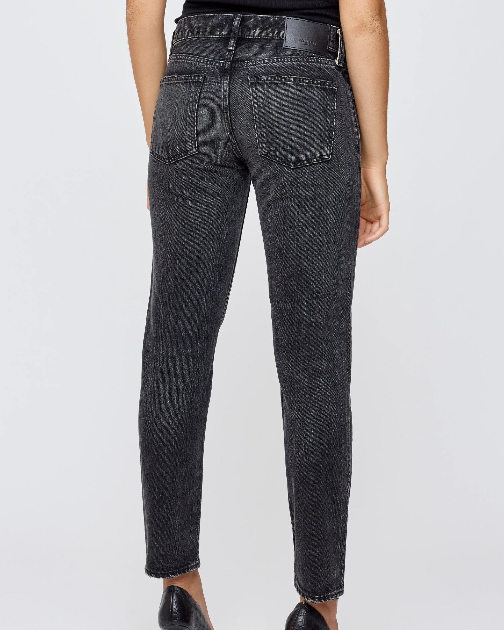 Person wearing black jeans on a white background