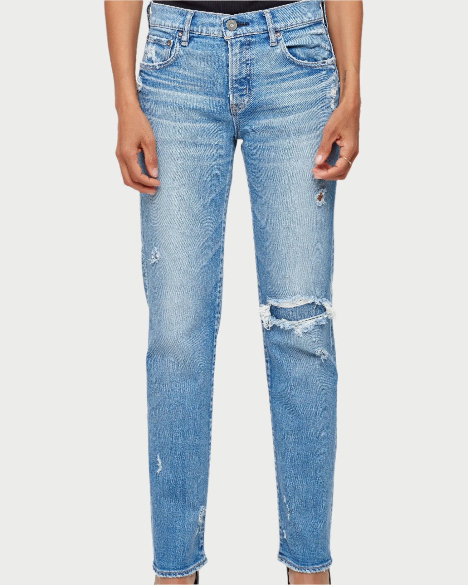 Light blue distressed jeans worn by a person on a white background