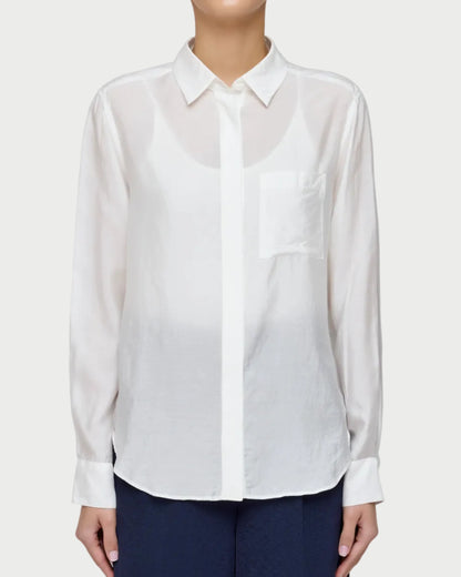 Person wearing a white shirt and navy pants on a plain background