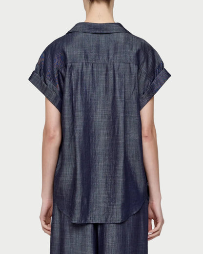 Person wearing a dark blue checkered outfit on a plain background