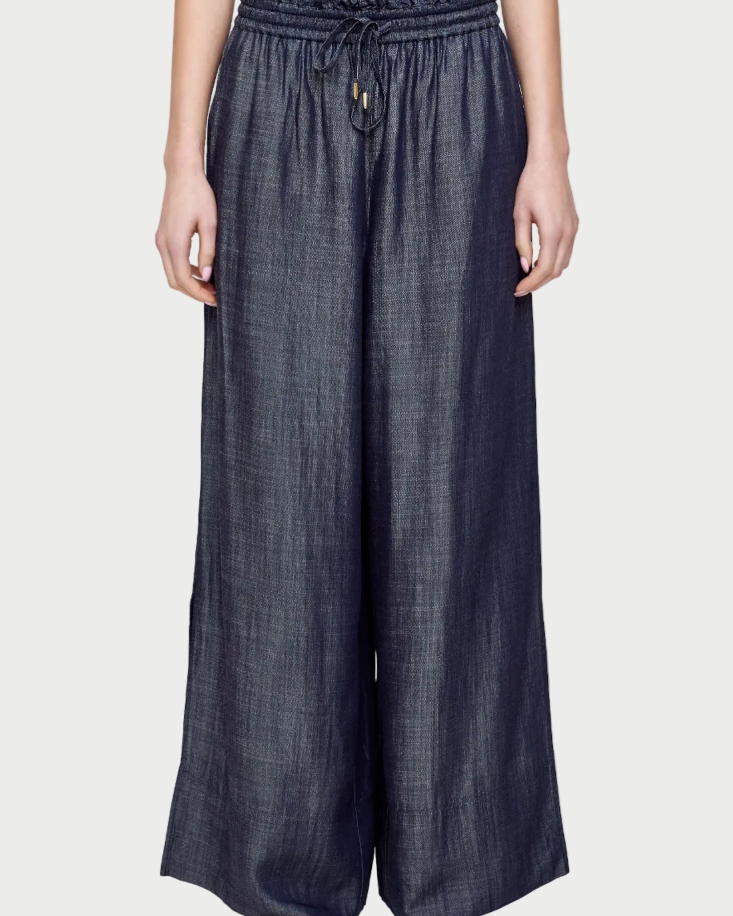 Person wearing dark denim pants on a white background