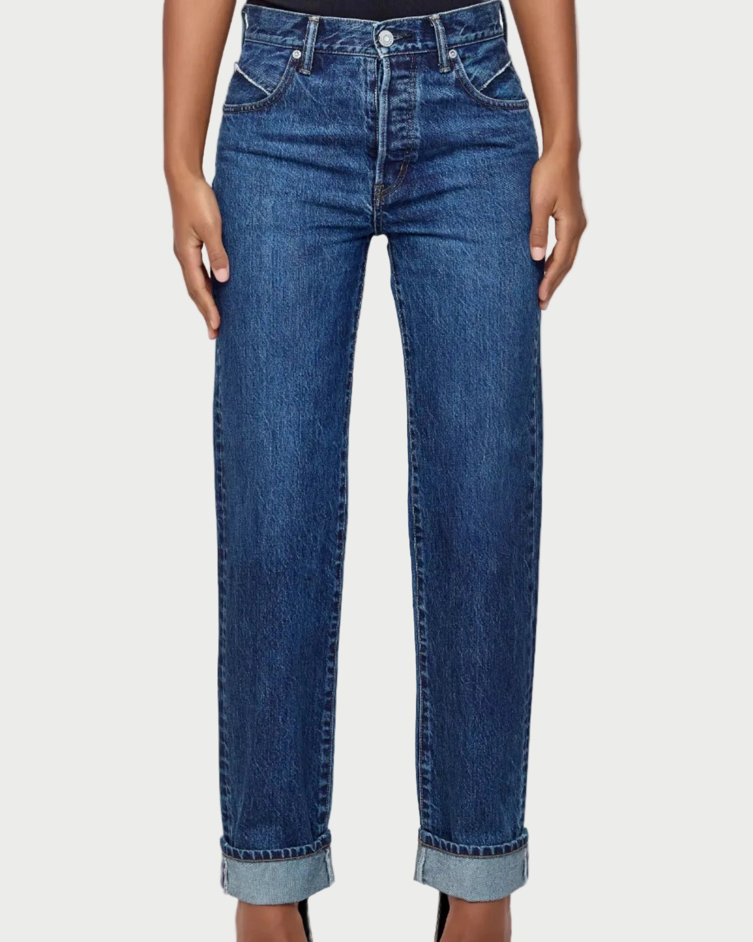 Person wearing blue jeans on a white background