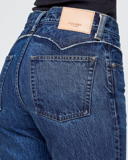 Close-up of blue jeans with a brand label on a white background